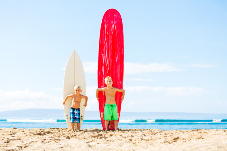 deux enfants avec des planches de tailles différentes, le style de surf sera adapté à la planche